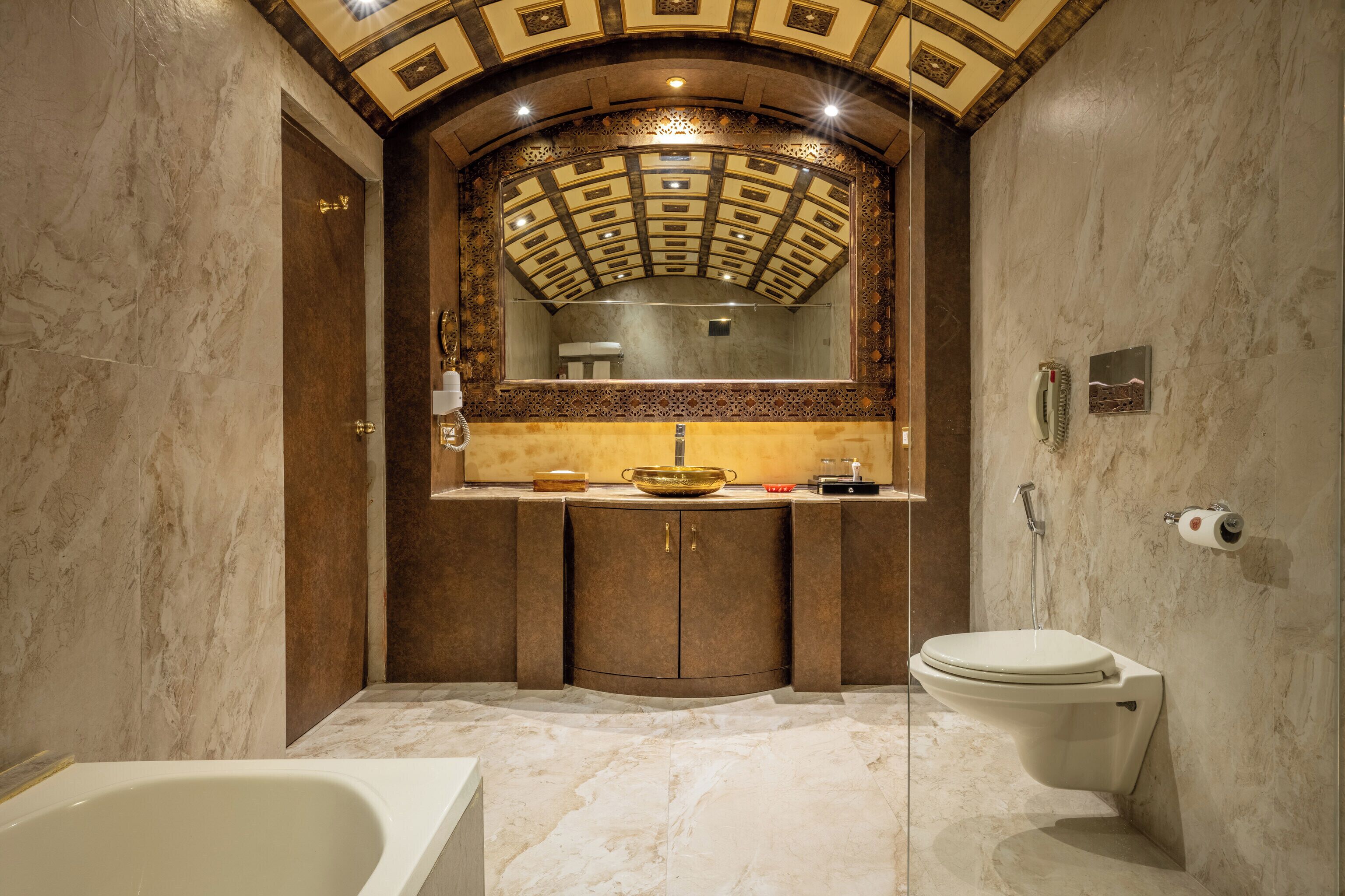 A bathroom with a bathtub, toilet, and vanity with a mirror.