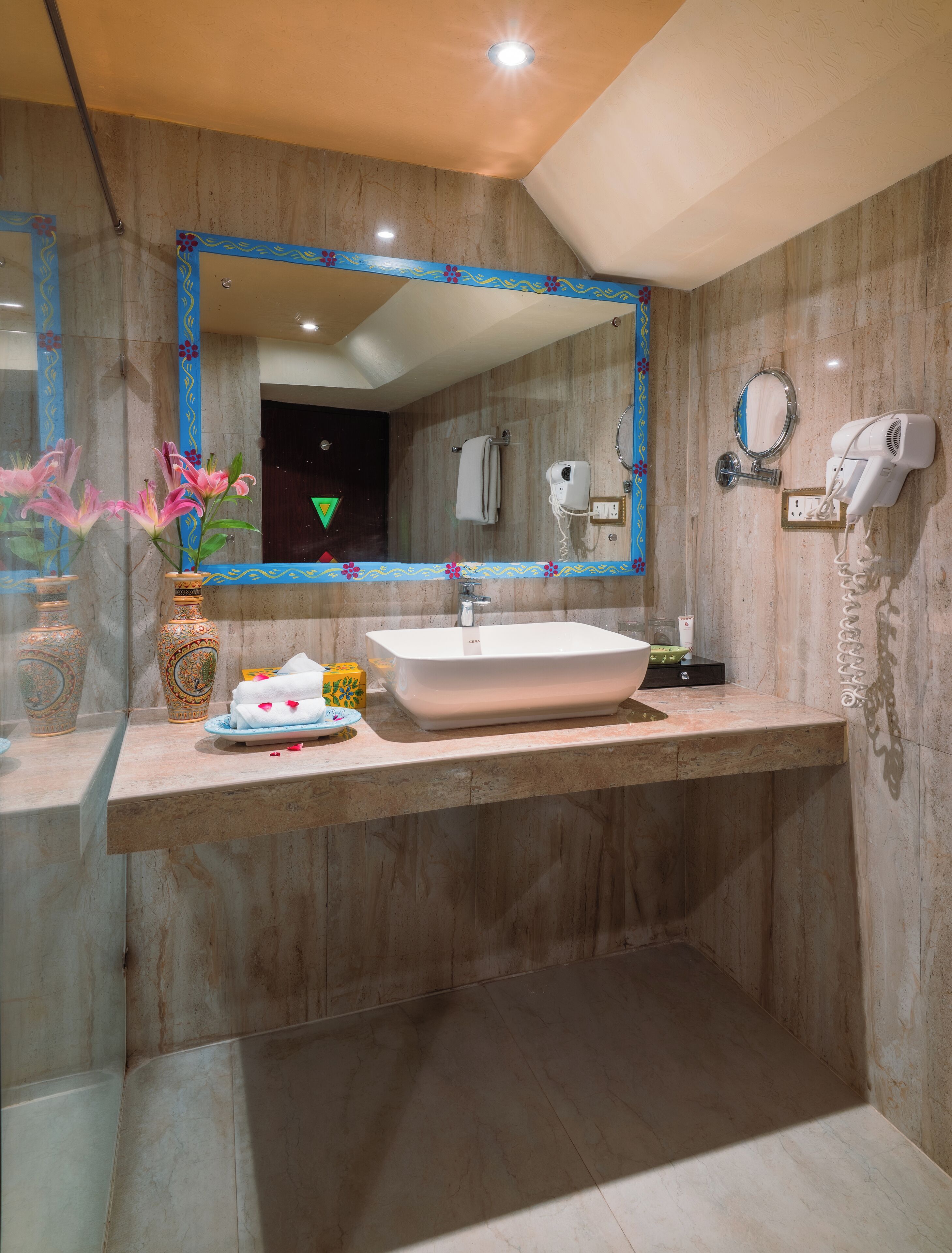 A bathroom with a large mirror, a sink, a towel rack, and a hairdryer.