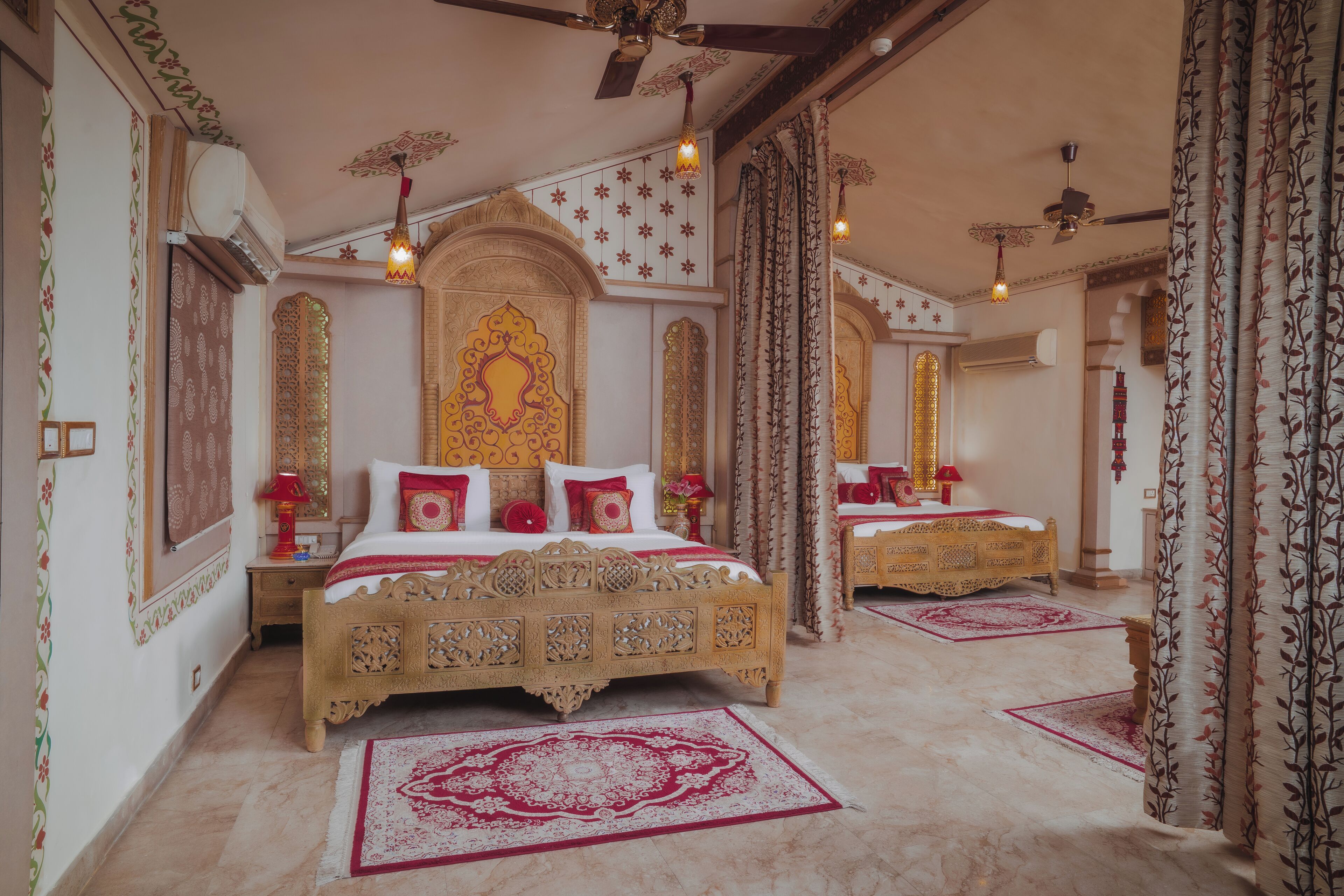 Quarto tradicional com uma cama grande, decorações de parede elaboradas e um tapete estampado.