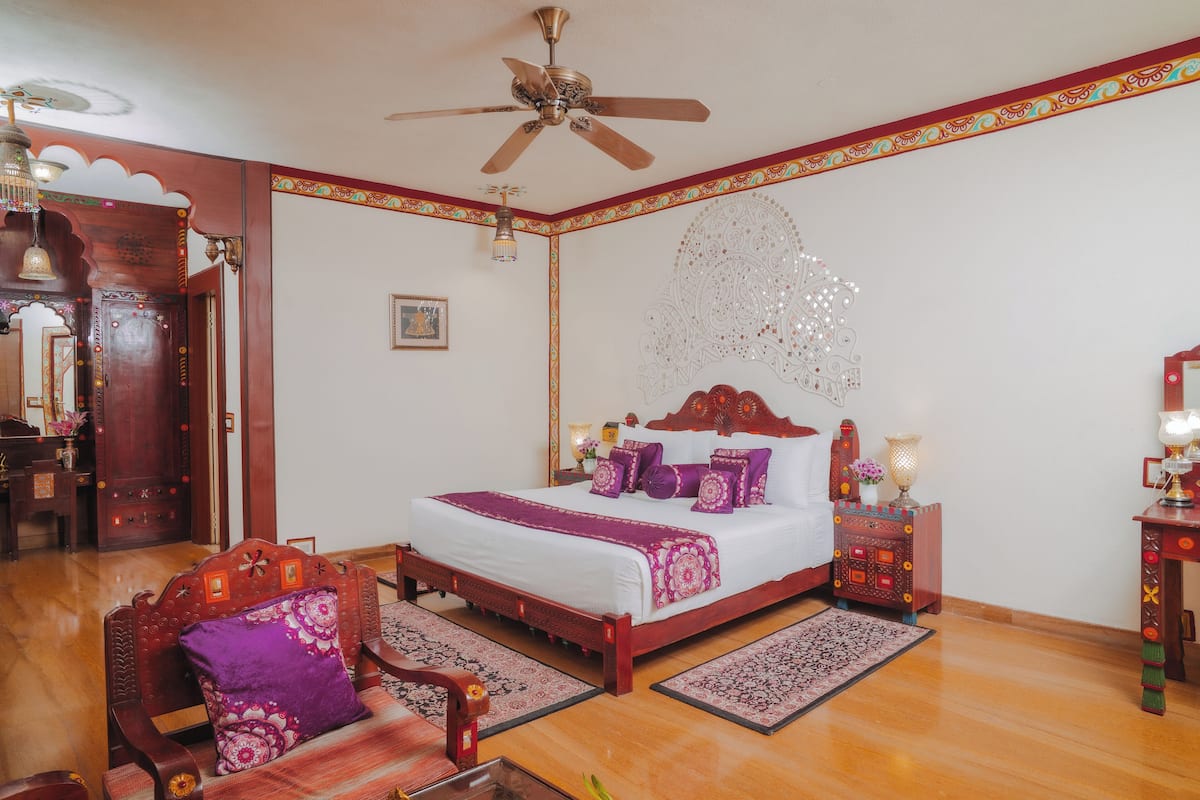 A bedroom with a wooden bed, a ceiling fan, and a decorative wall hanging.