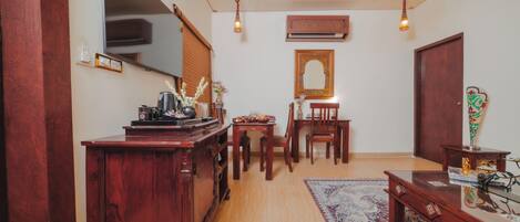 A traditional room with a wooden desk, a mirror, a patterned rug, and a ceiling with ornate design.