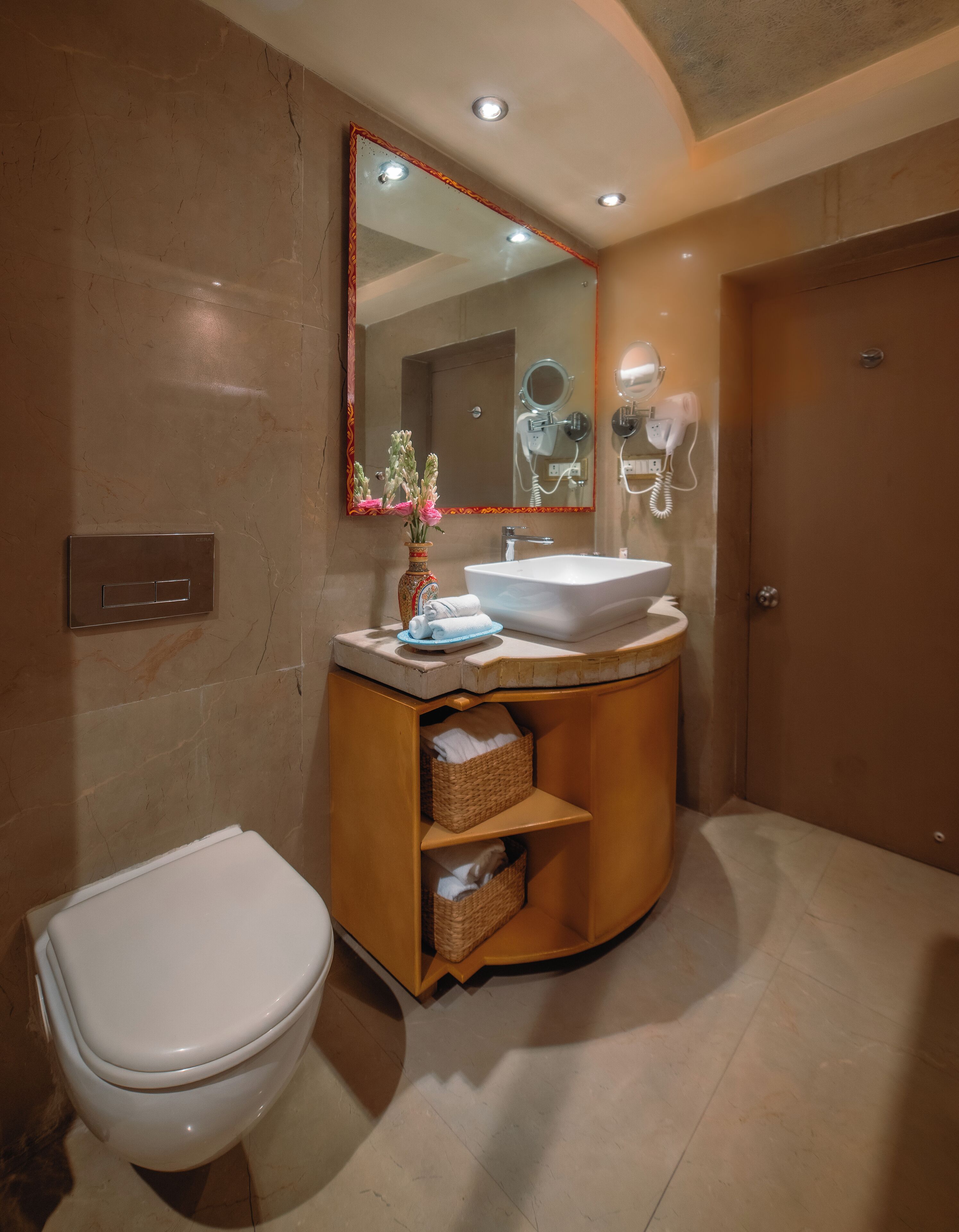 Une salle de bain moderne équipée de toilettes, d’un meuble-lavabo, d’un lavabo et d’un miroir.