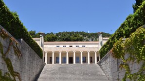 A grand staircase leading to a classical building with columns, surrounded by greenery. - Sunset Split Rooms (Podstrana)