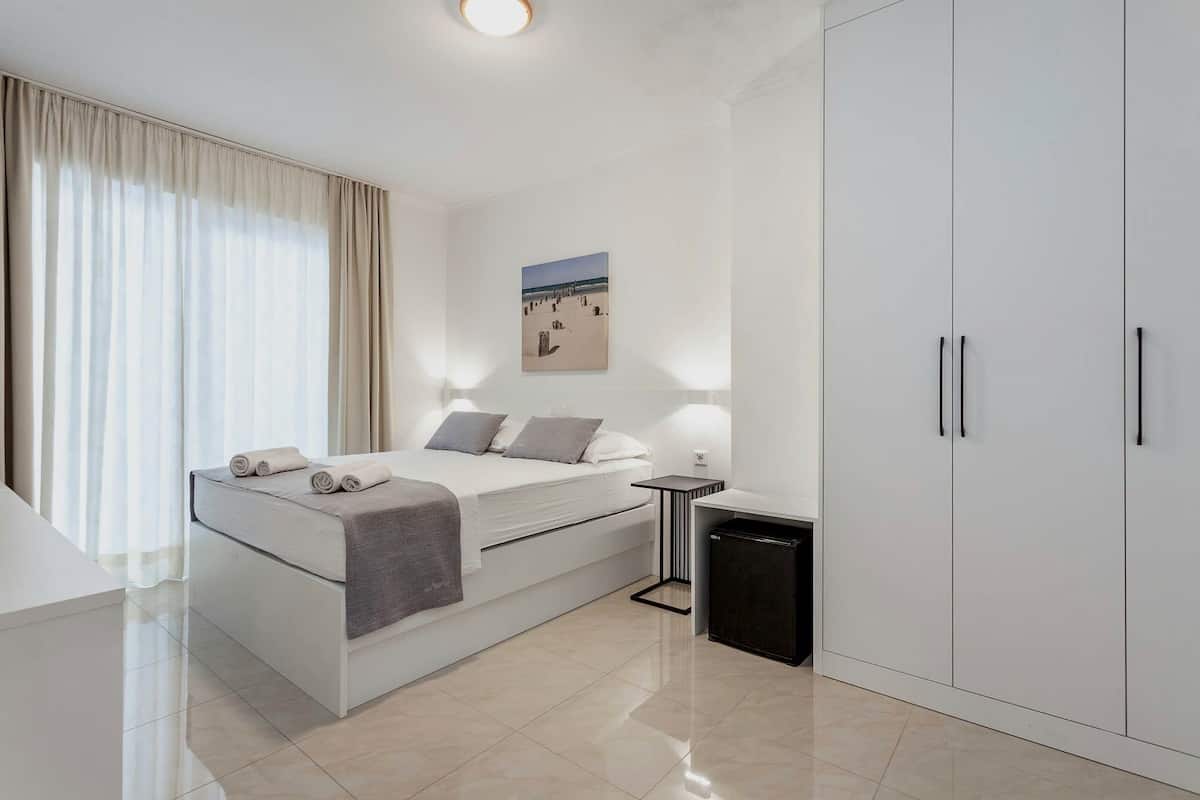 A modern bedroom with a bed, bedside table, and a wardrobe.