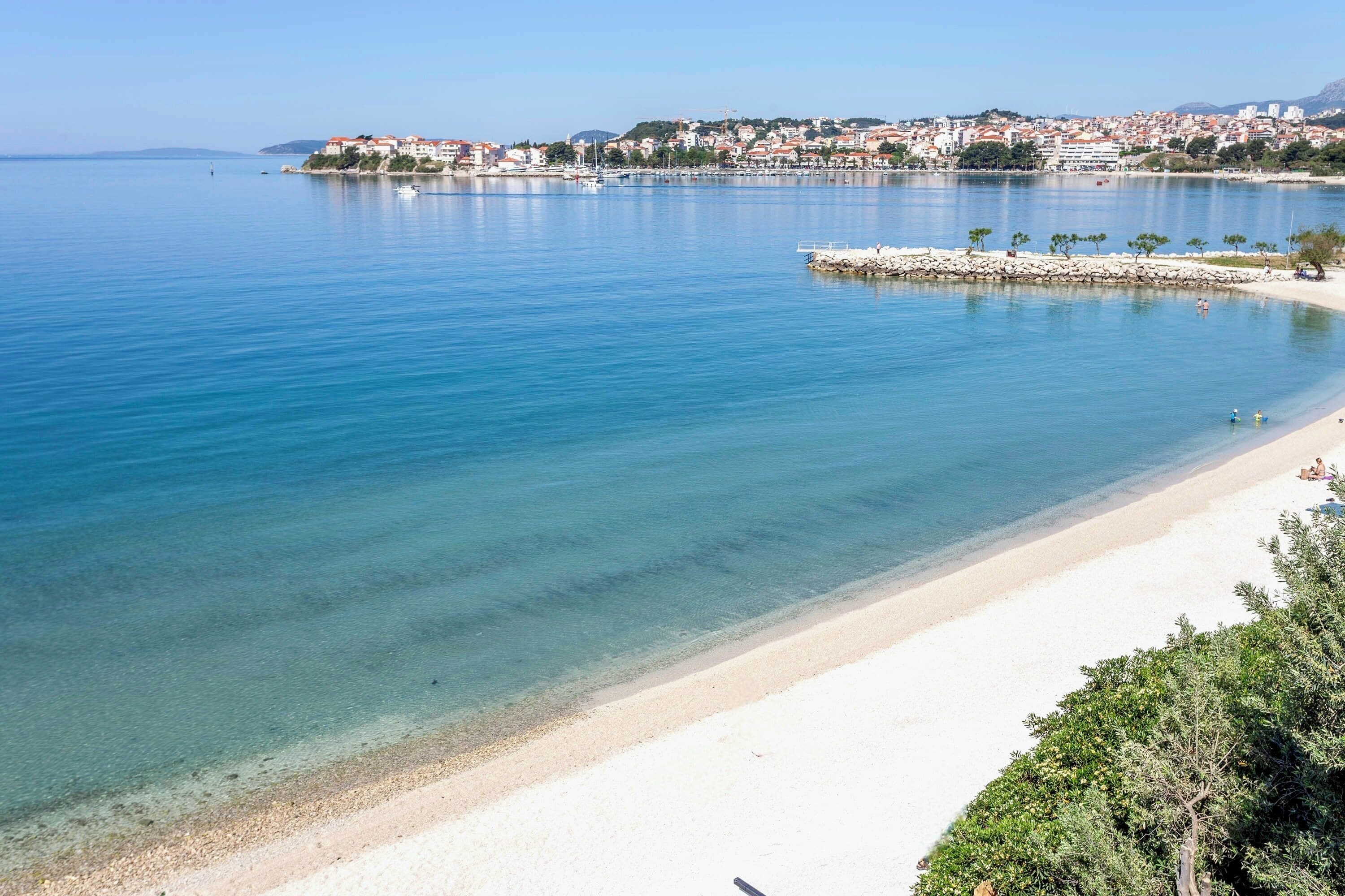 A coastal town with a sandy beach and clear blue waters.