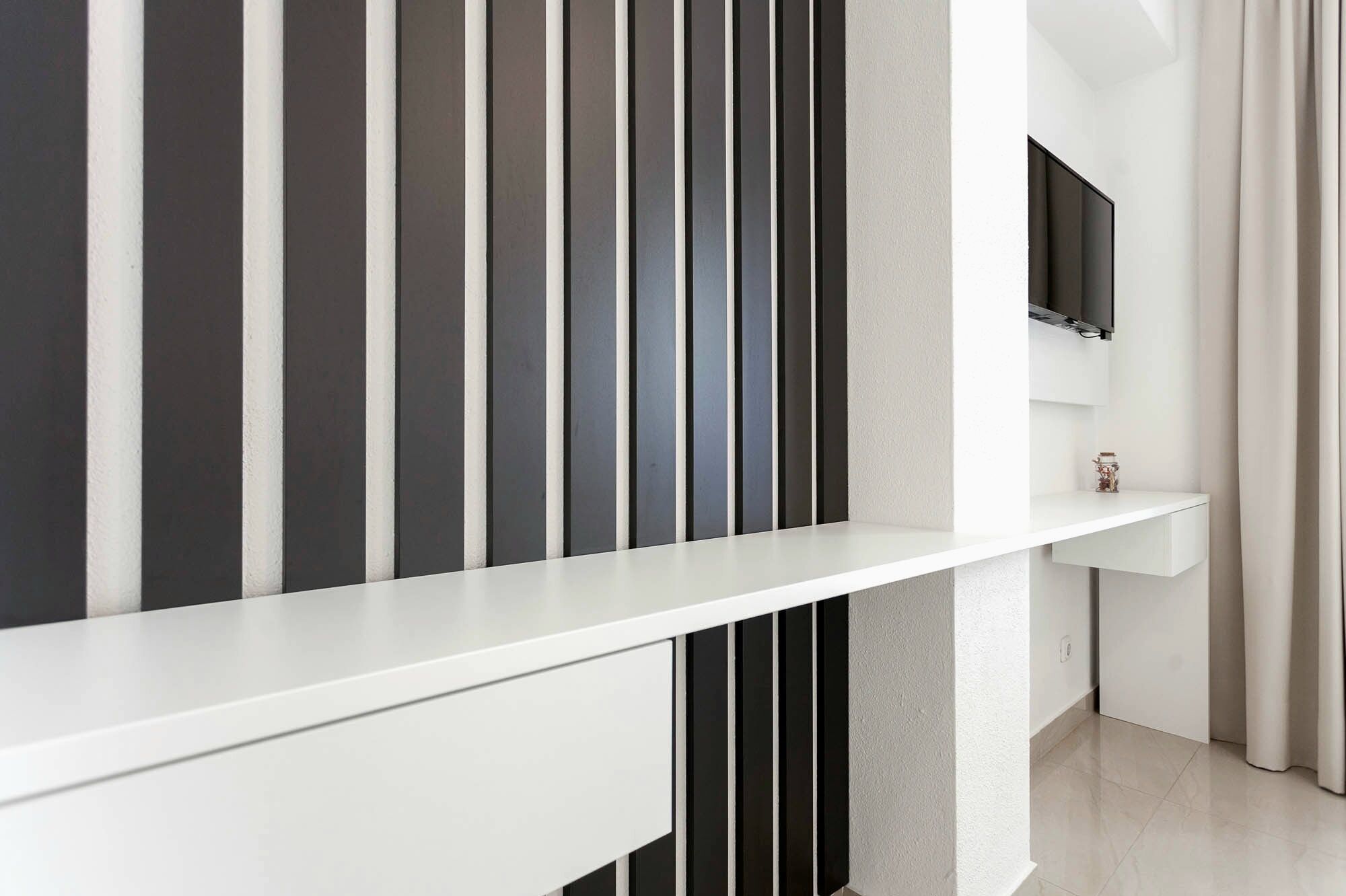 A modern interior with a white console table, a mounted TV, and a minimalist design.