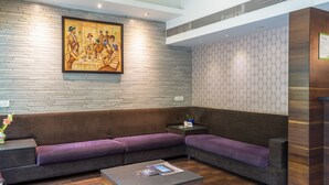 Un vestíbulo moderno con un sofá modular, una mesa de centro y un cuadro en la pared.