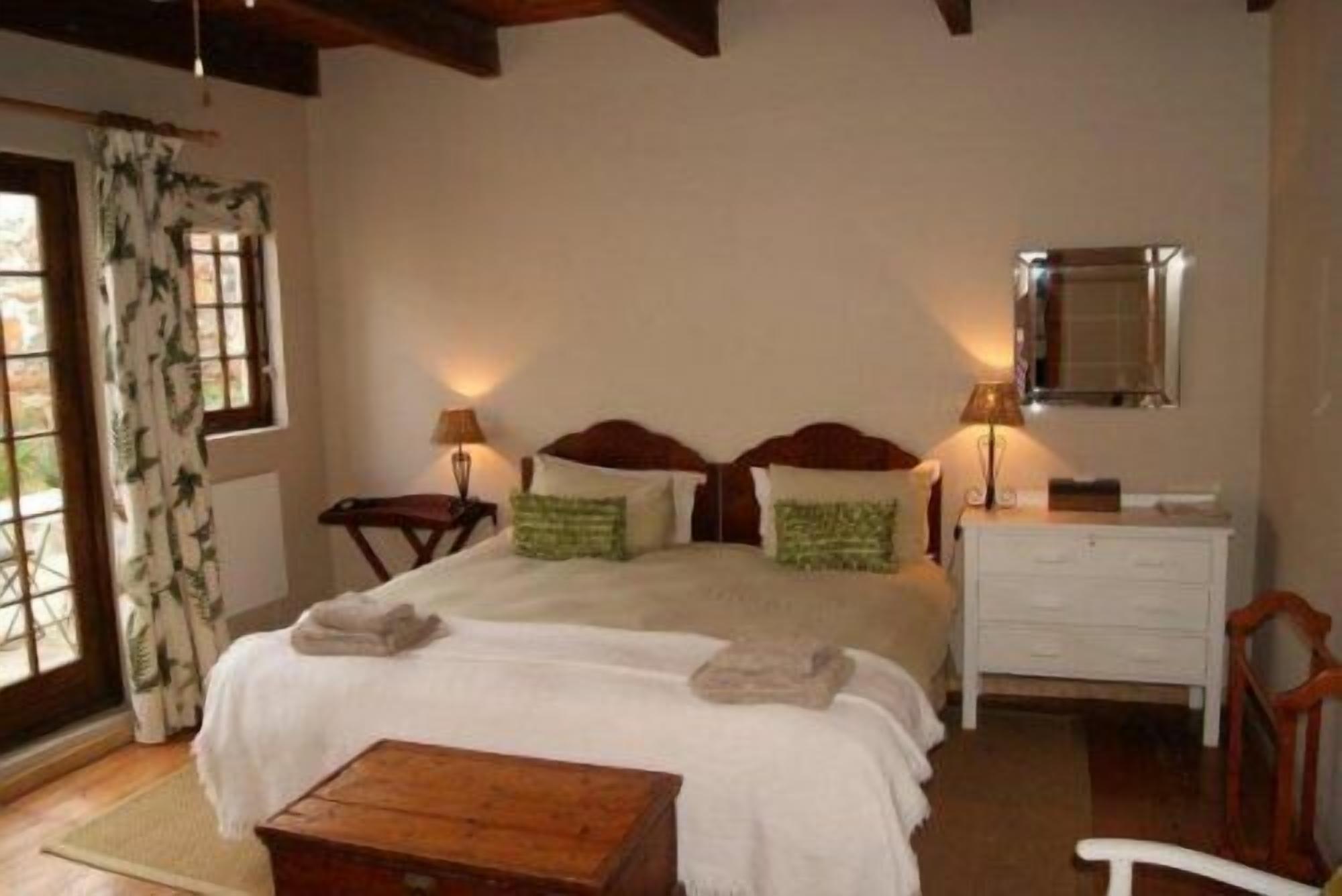 A bedroom with a bed, bedside tables, a dresser, and a mirror.