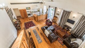 Amplia sala de estar con una mesa de comedor de madera, un sofá y una televisión.