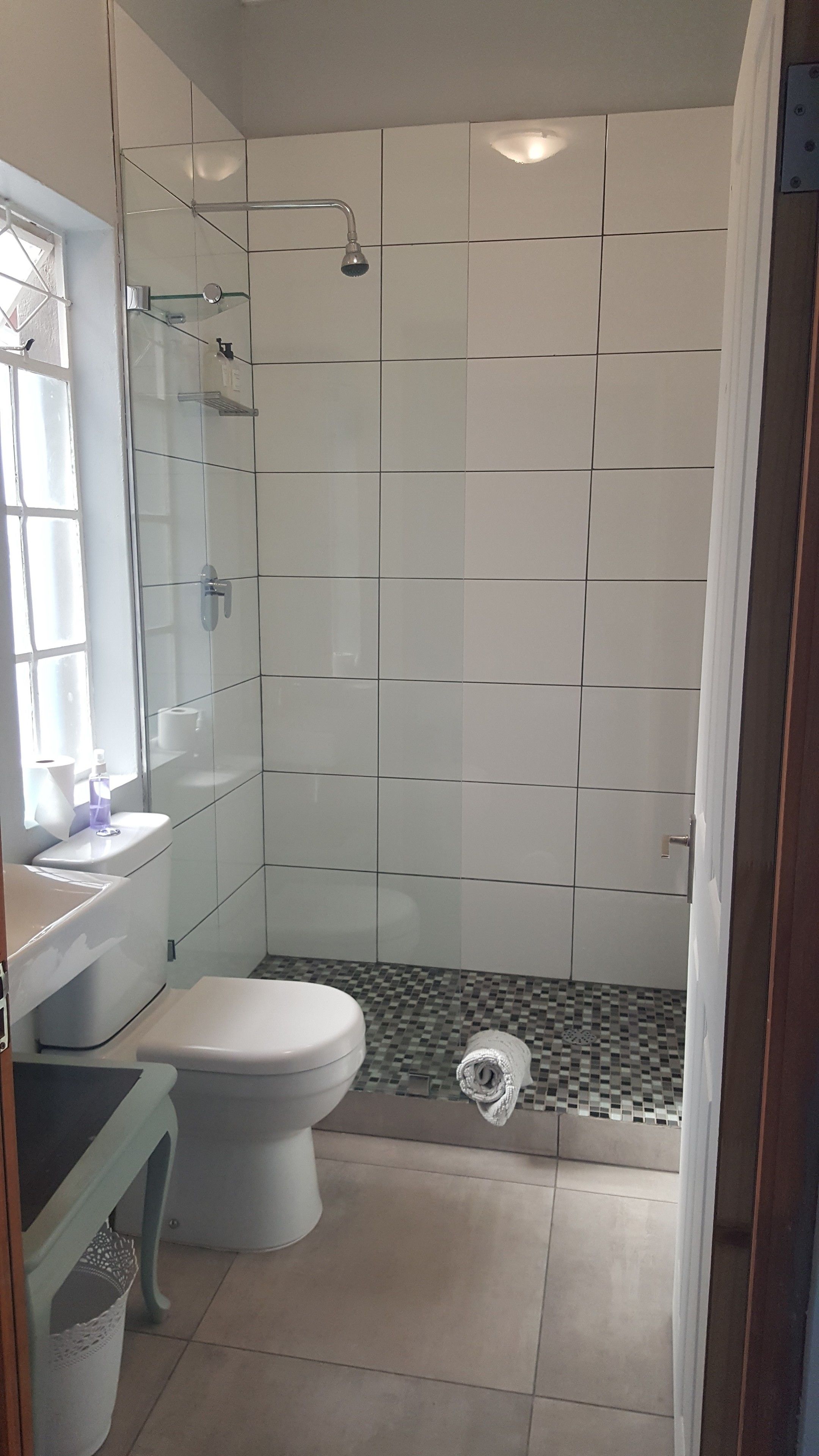 A bathroom with a shower, toilet, and sink.