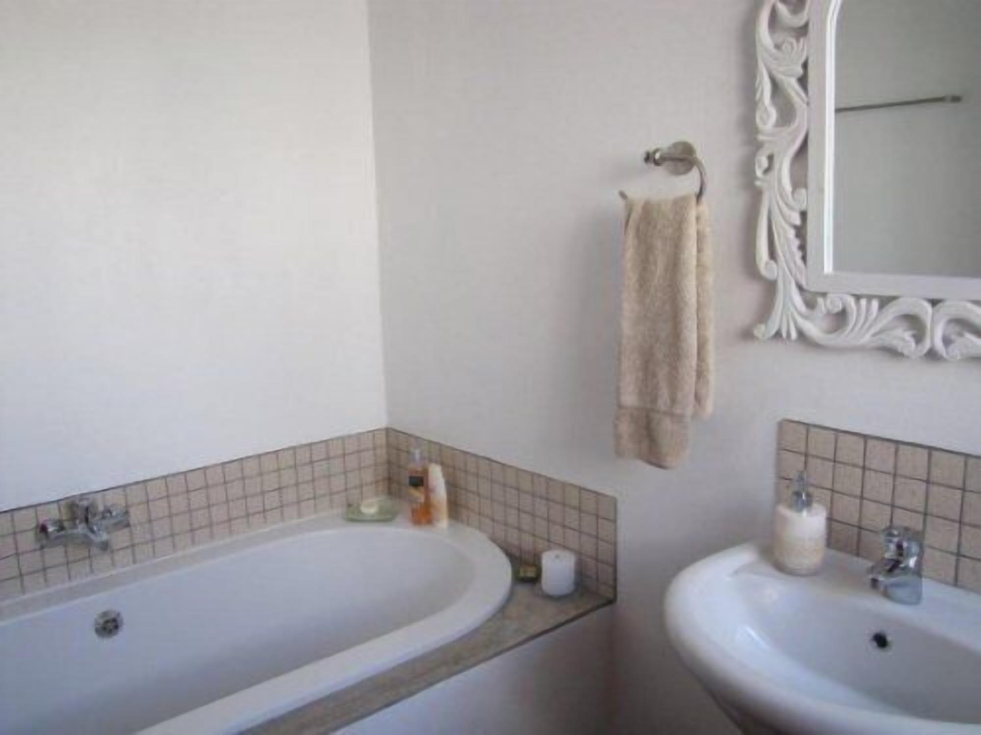 Un baño con bañera, lavabo y espejo.