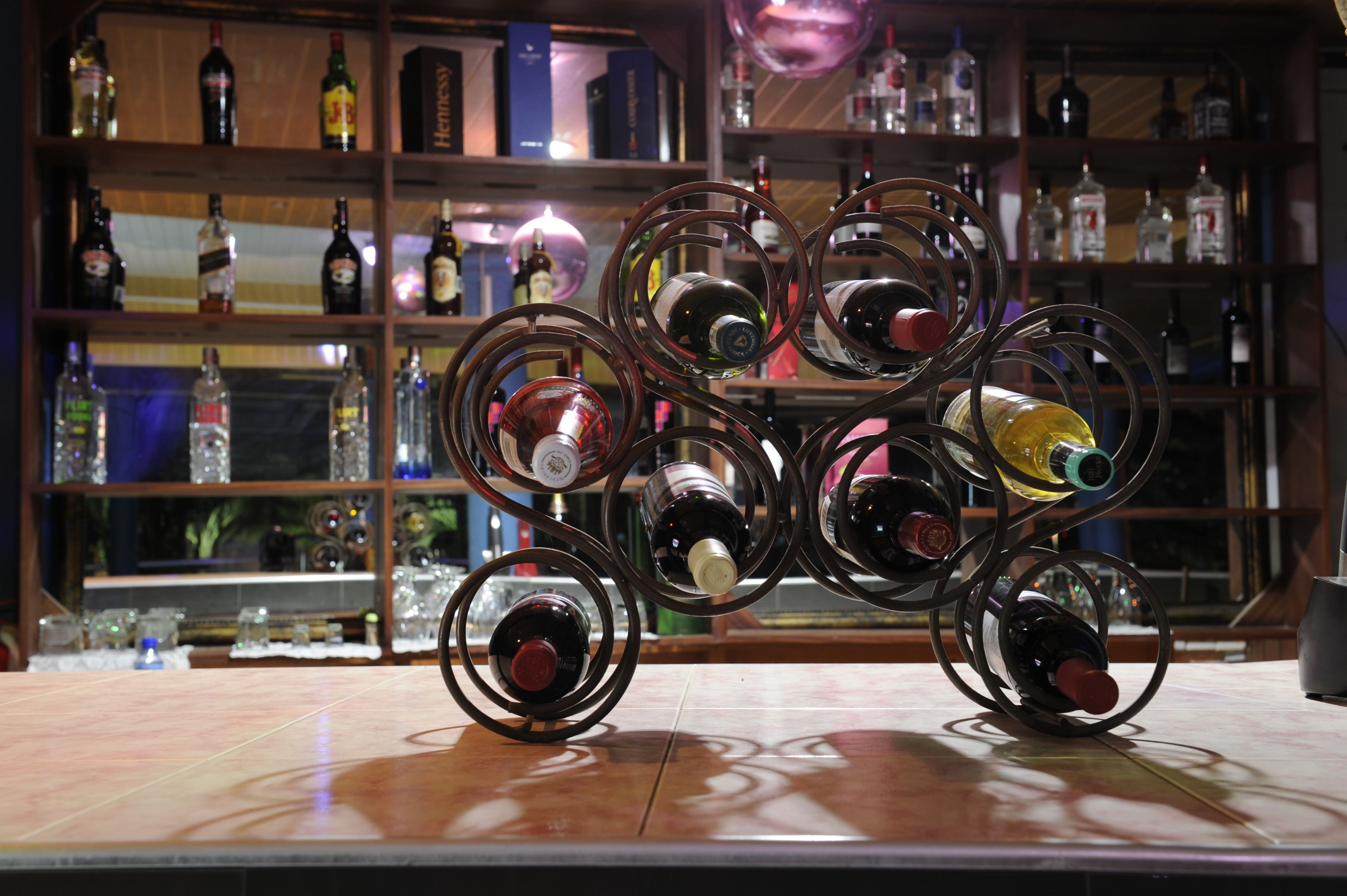 Una estantería para vinos con varias botellas en un bar.