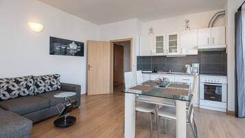 Departamento Deluxe, 1 habitación, balcón, vista al mar | Sala de estar | Smart TV de 73 cm con canales vía satélite