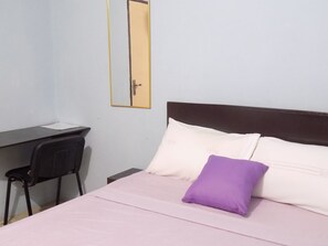A room with a bed, a desk, and a chair.