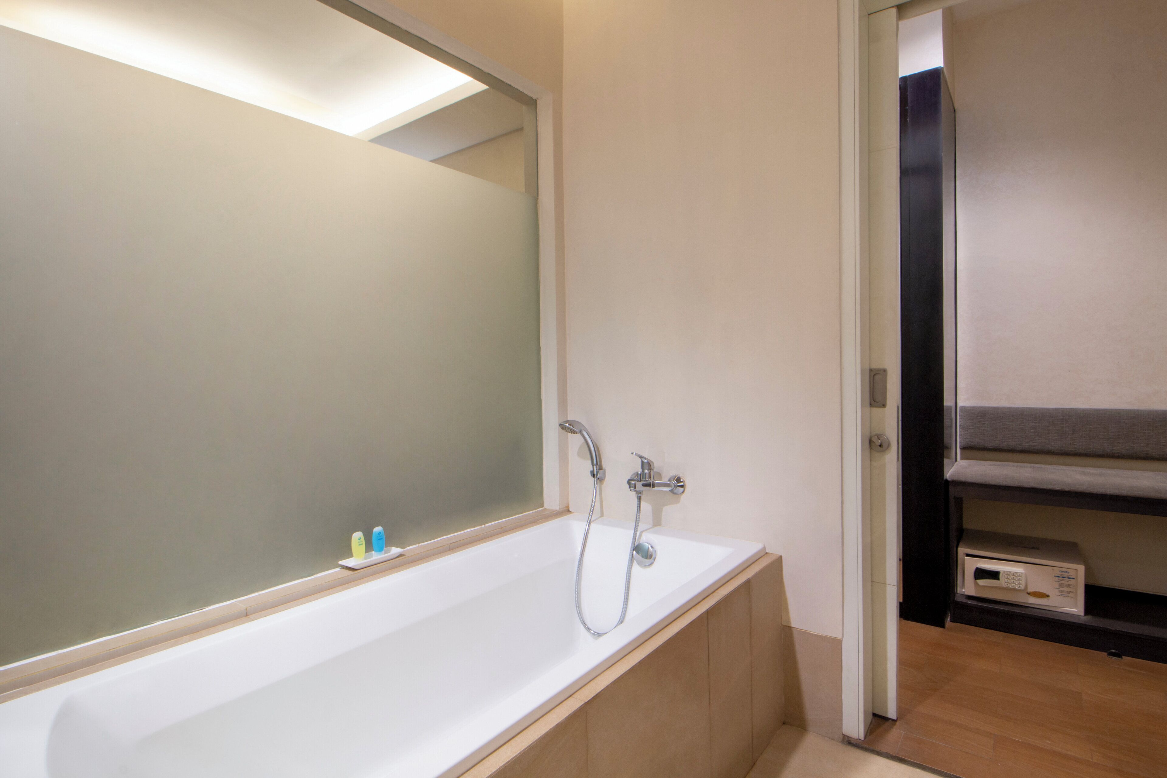 A modern bathroom with a large mirror, a bathtub, and a shower.