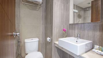 Un baño moderno con inodoro, lavamanos y ducha.
