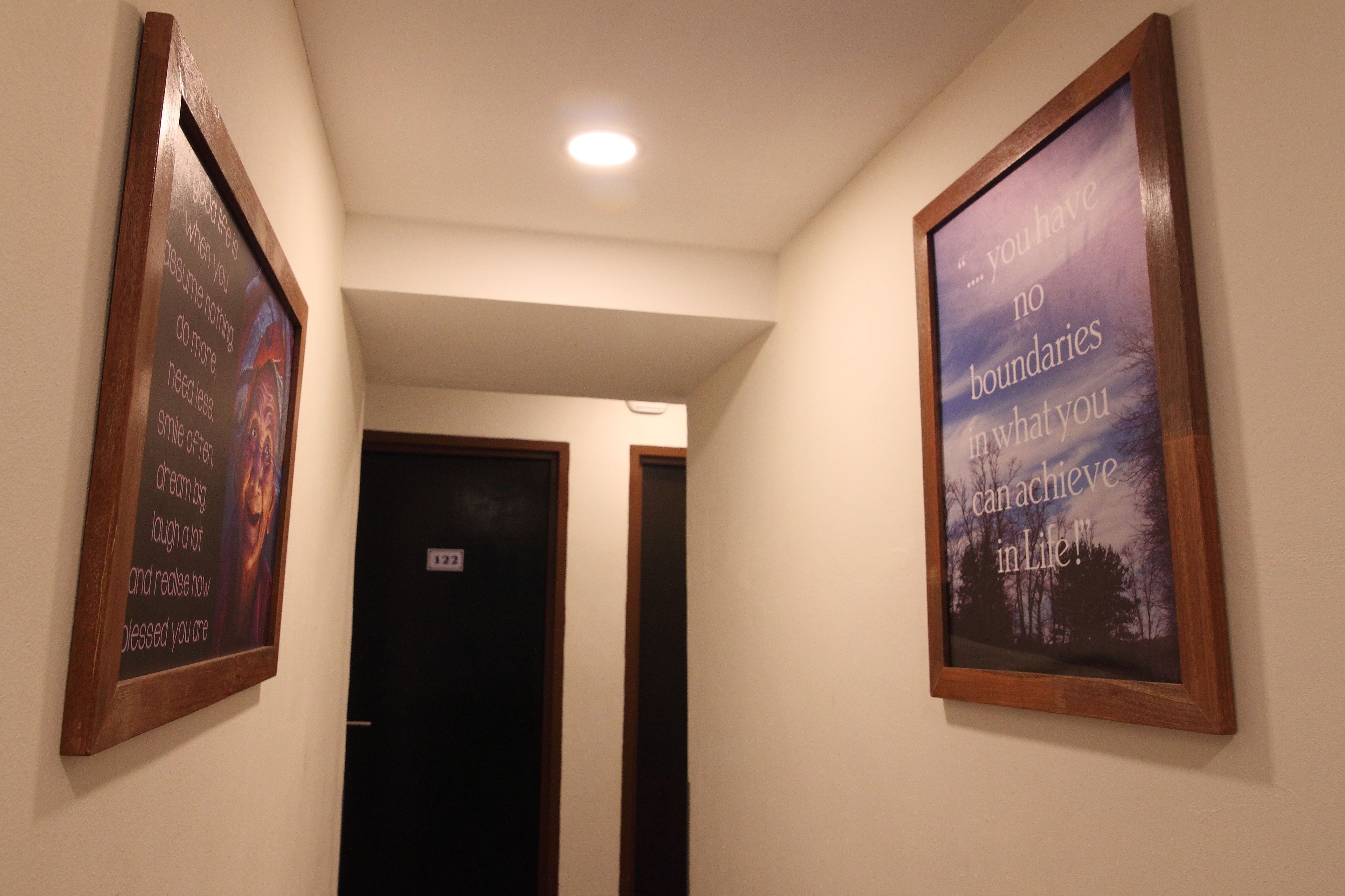 A hallway with two framed inspirational quotes on the walls.