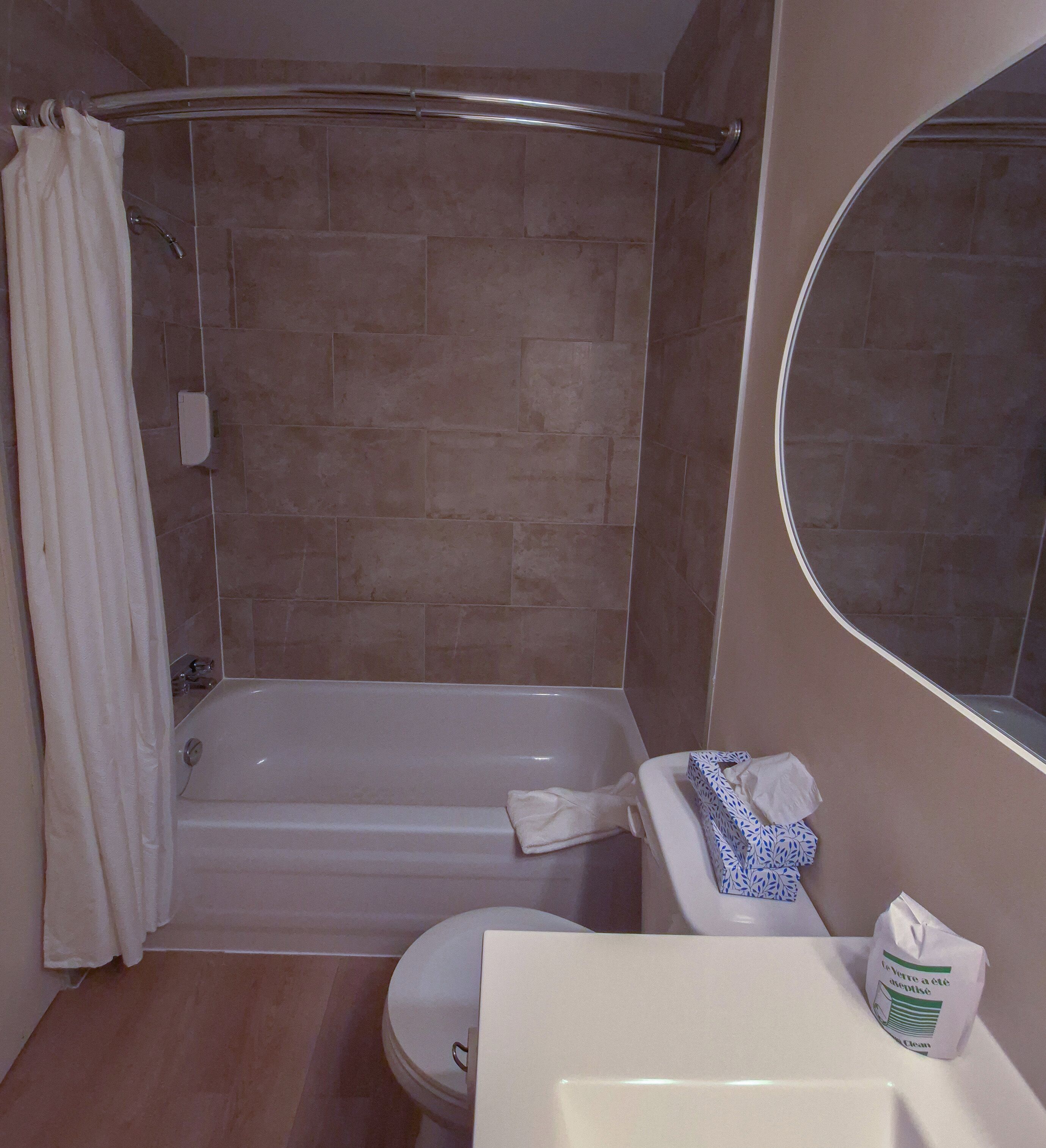Une salle de bain avec une baignoire, des toilettes et un lavabo avec un miroir.