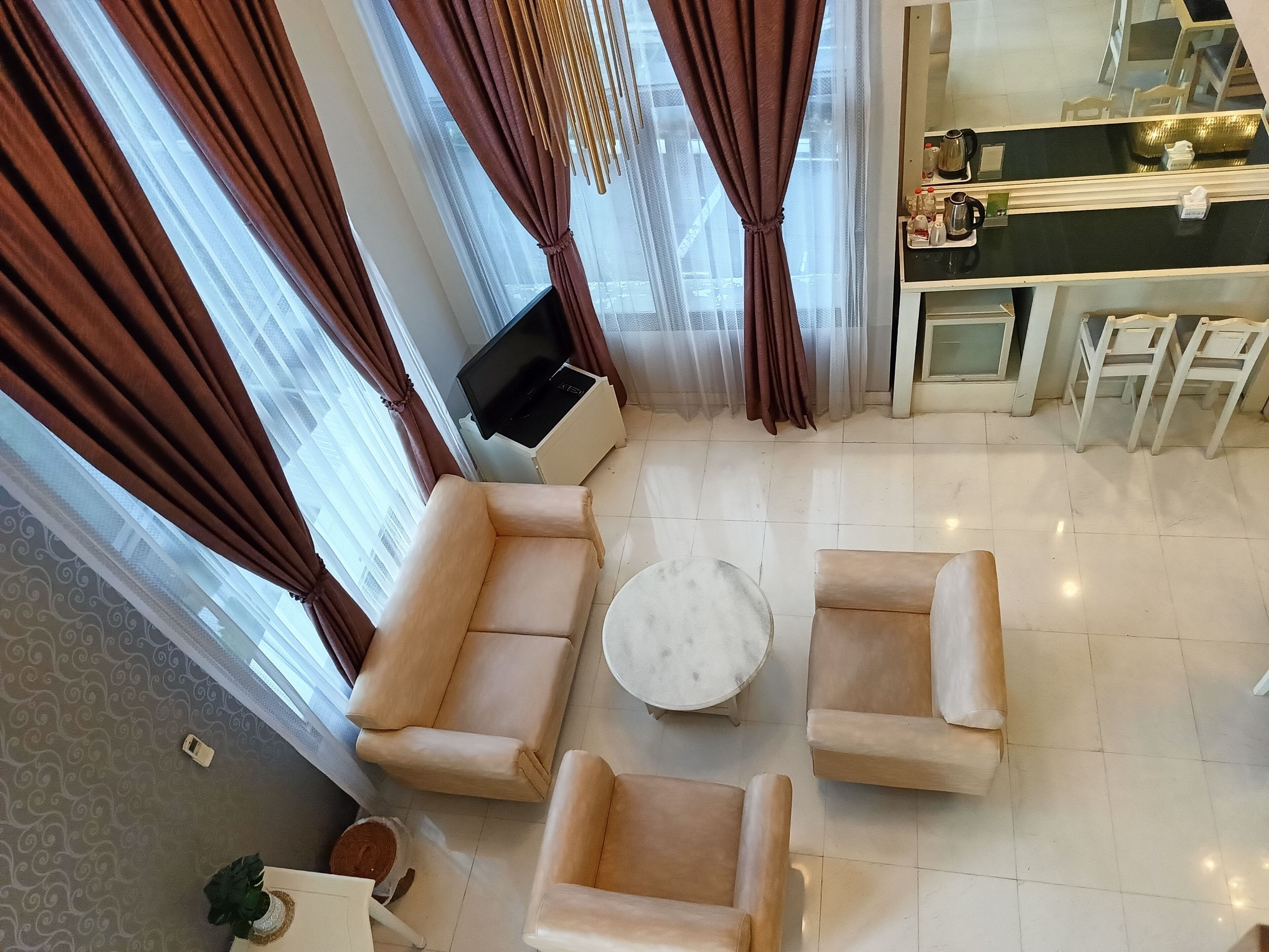 Una sala moderna con un conjunto de sofás, una mesa de centro y un comedor con sillas y una barra de cocina.