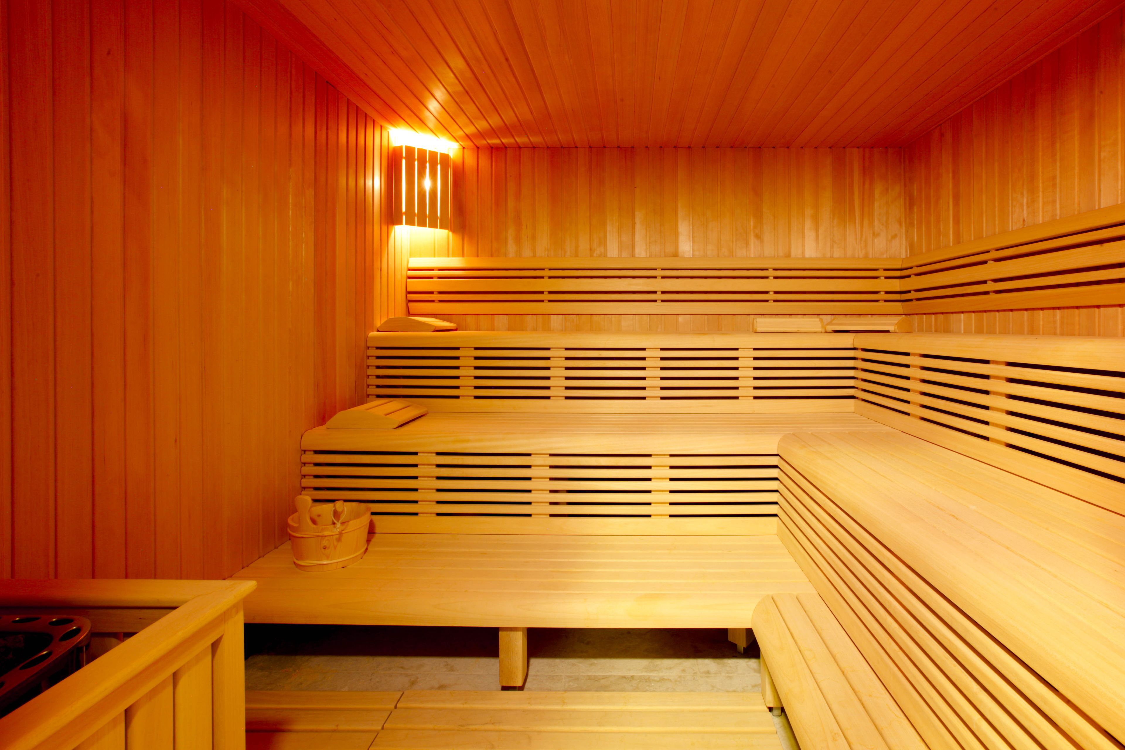 Un sauna avec des bancs en bois et un banc muni d’un porte-serviettes.