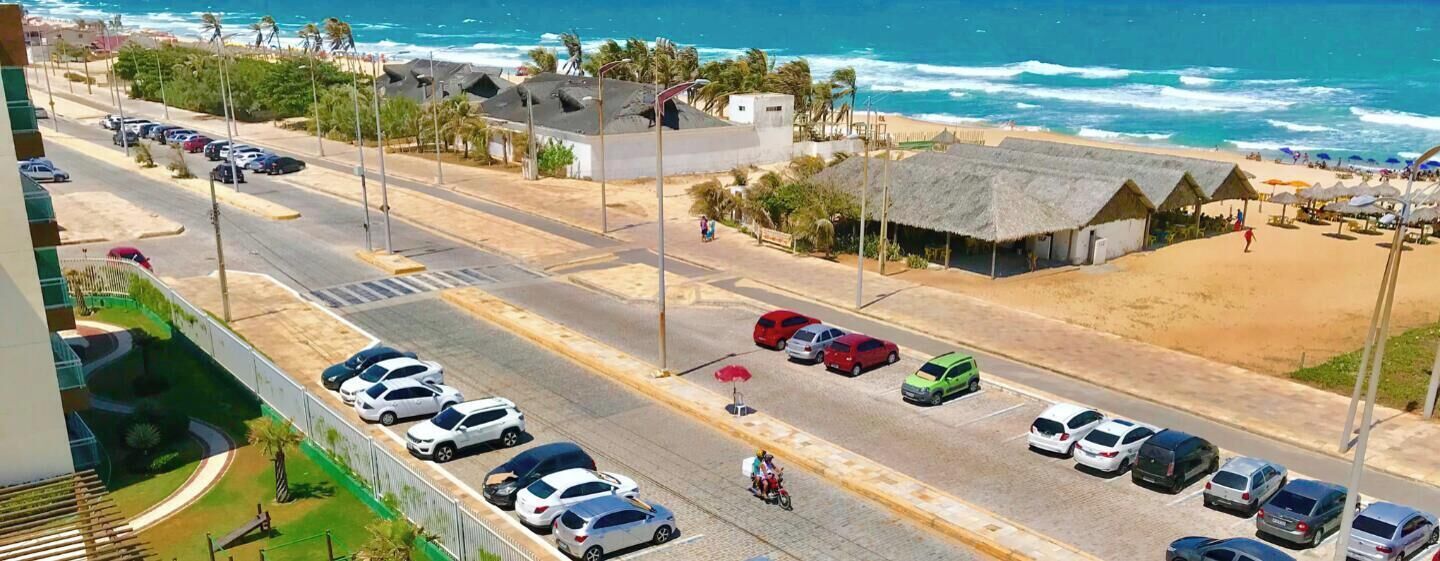 Na praia, areia branca, espreguiçadeiras, guarda-sóis 