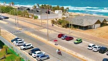 Na praia, areia branca, espreguiçadeiras, guarda-sóis