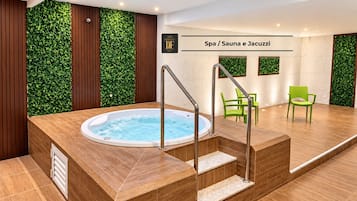 Espaço de spa com hidromassagem, escadas de madeira e cadeiras verdes.