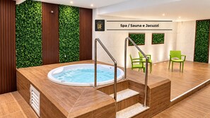 Un espacio de spa con un jacuzzi, escalones de madera y sillas verdes.