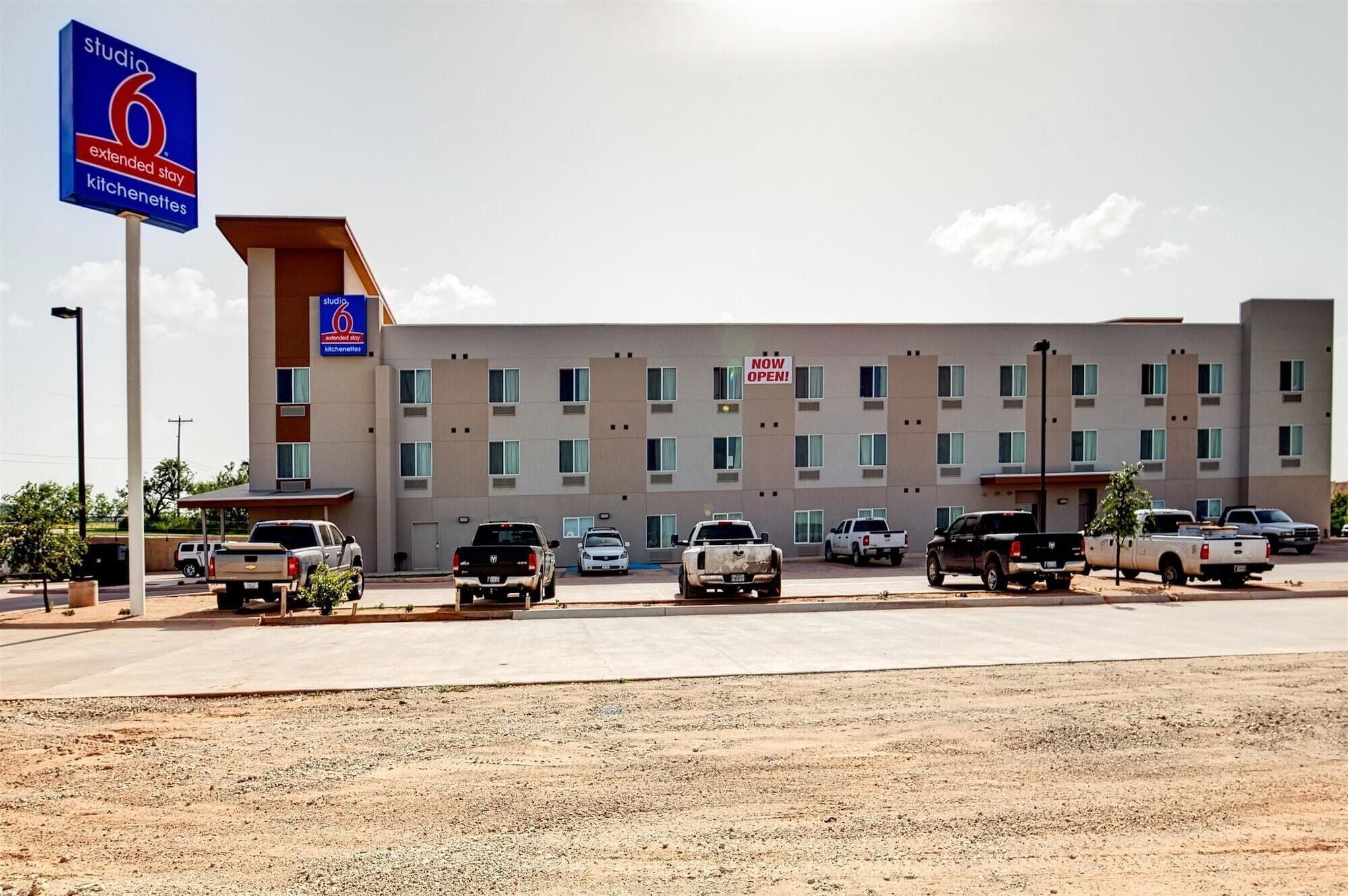 A multi-story hotel with a sign indicating 'Studio 6 Extended Stay Kitchens'.