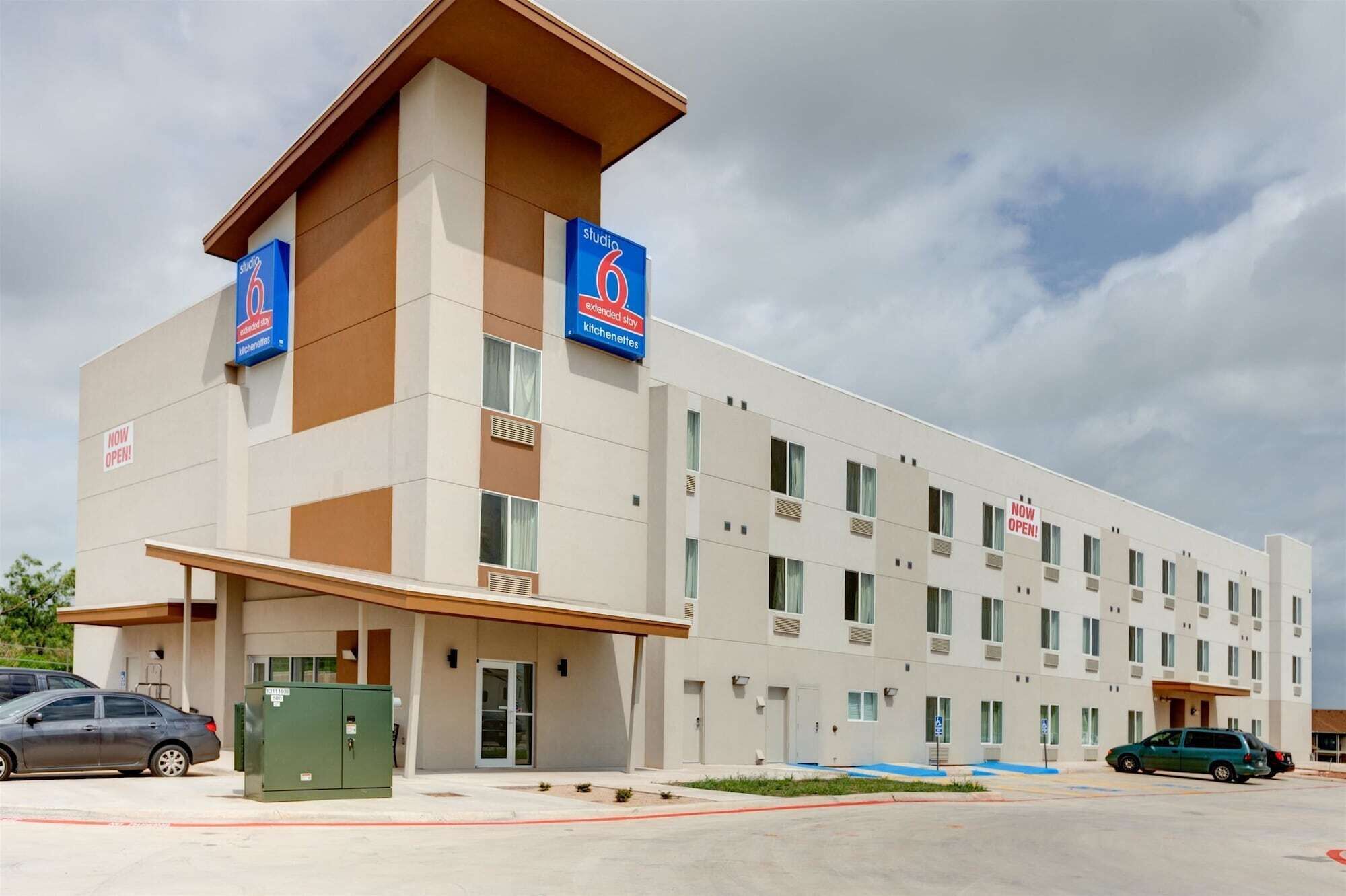 A modern hotel with a flat facade, multiple windows, and a prominent entrance.