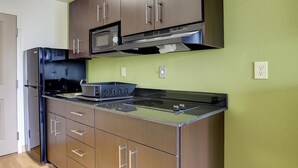 A kitchen with stainless steel appliances, a microwave, and a stove. - Studio 6 Sweetwater, TX (Sweetwater)