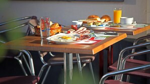 A breakfast table with various food items and a glass of orange juice. - Hotel Le Terminus d'Albi (Albi)