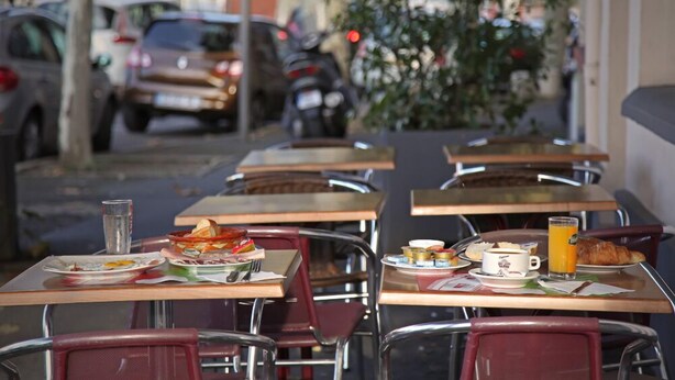 A café with tables and chairs, outdoor seating, and parked cars in the background. - Hotel Le Terminus d'Albi (Albi)