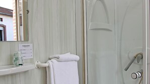 A bathroom with a glass-enclosed shower, a sink, and a mirror. - Hotel Le Terminus d'Albi (Albi)