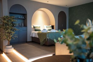 Une chambre à coucher moderne avec un lit, des tables de chevet et une plante en pot.