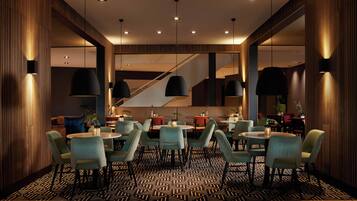 A modern dining area with multiple tables and chairs, a patterned floor, and a staircase in the background.