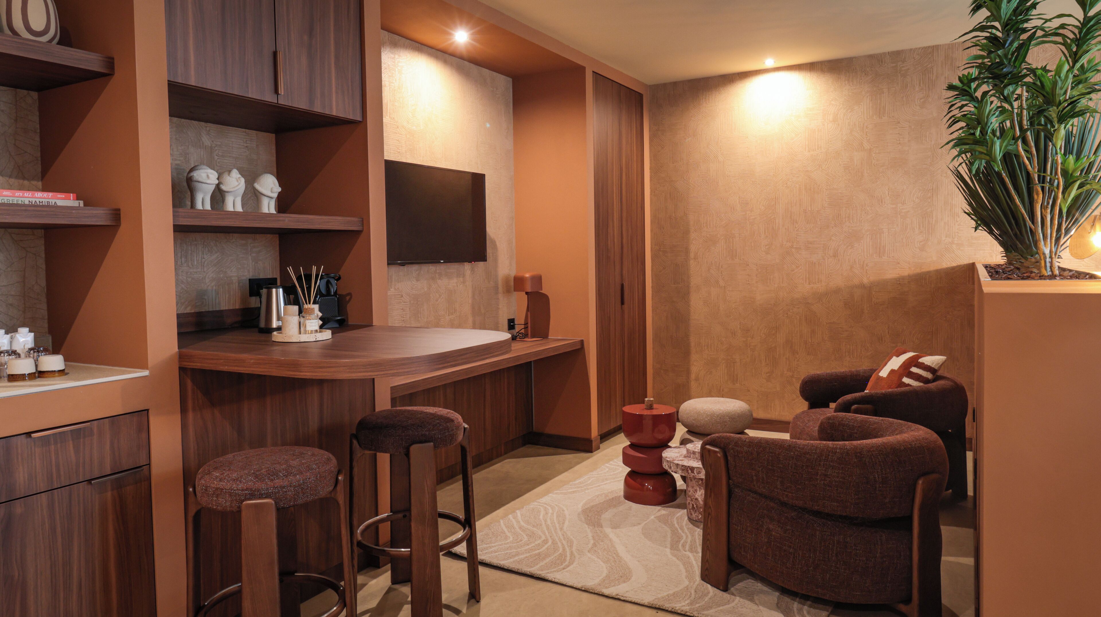 Un baño moderno con tocador de madera, espejo, lavamanos y una zona de bar con taburetes.
