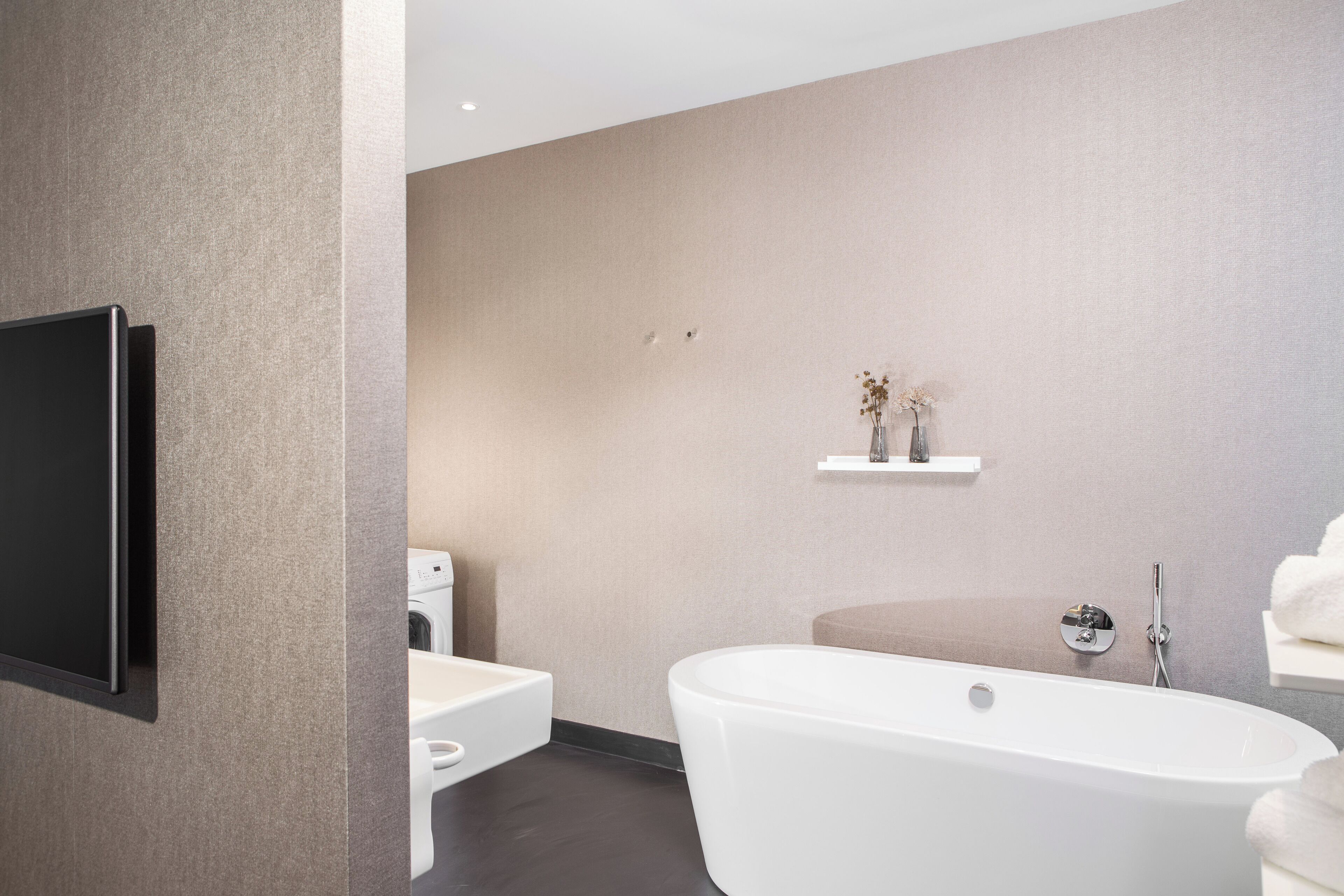 Un baño moderno con una bañera independiente, un inodoro y un lavabo.