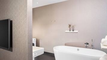 Un baño moderno con una bañera independiente, un inodoro y un lavabo.