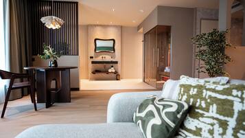 A modern living room with a sofa, a desk, and a hanging light fixture.