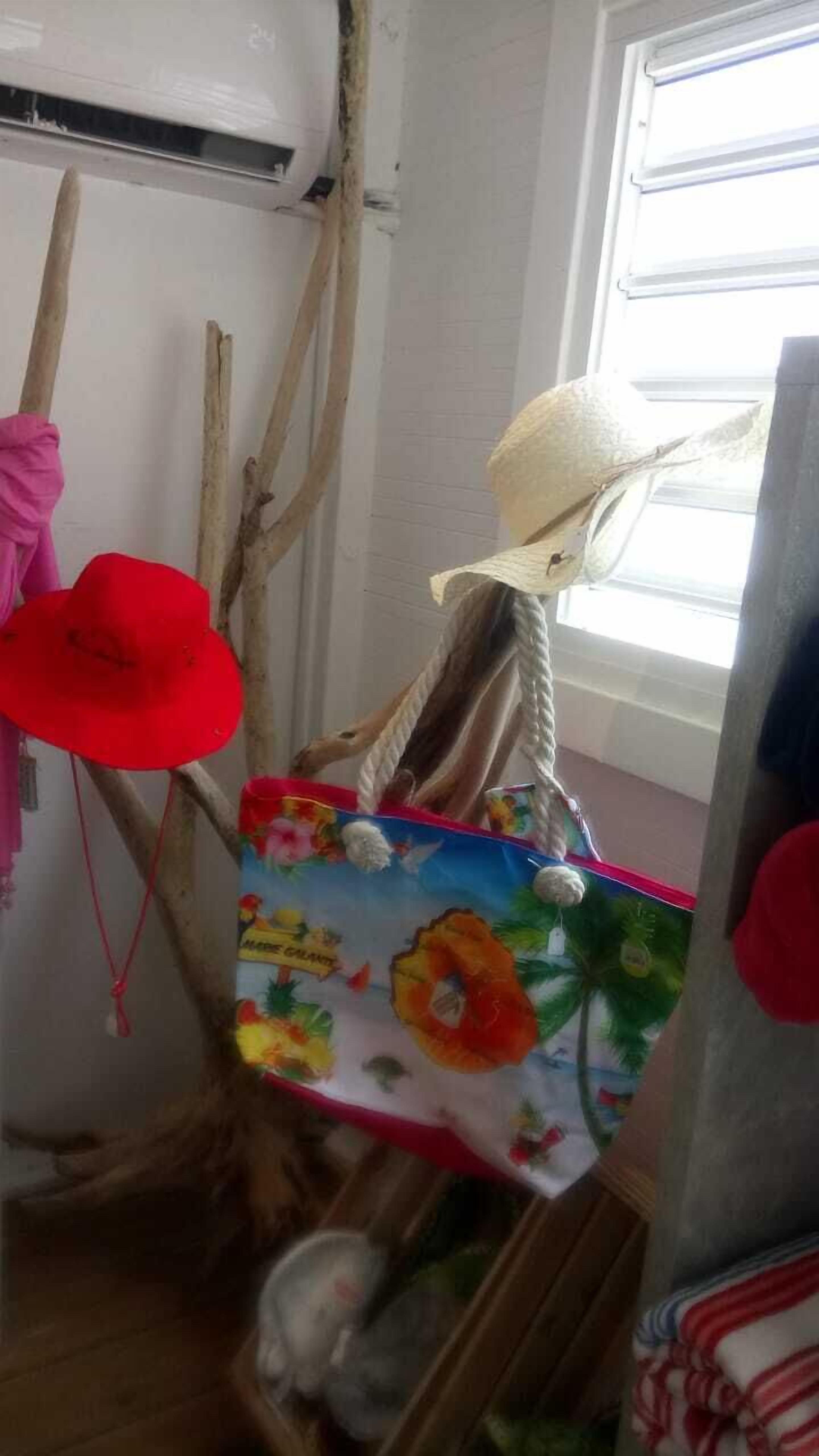 A room with a window, a red hat, a doll, and a colorful bag.