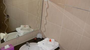 Un baño con un lavabo redondo, un espejo y un perchero para toallas.