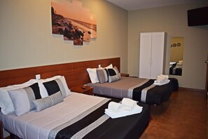 A hotel room with two beds, a wooden headboard, a wall-mounted TV, and a mirror reflecting the room. - Residencial Belo Horizonte (Porto)