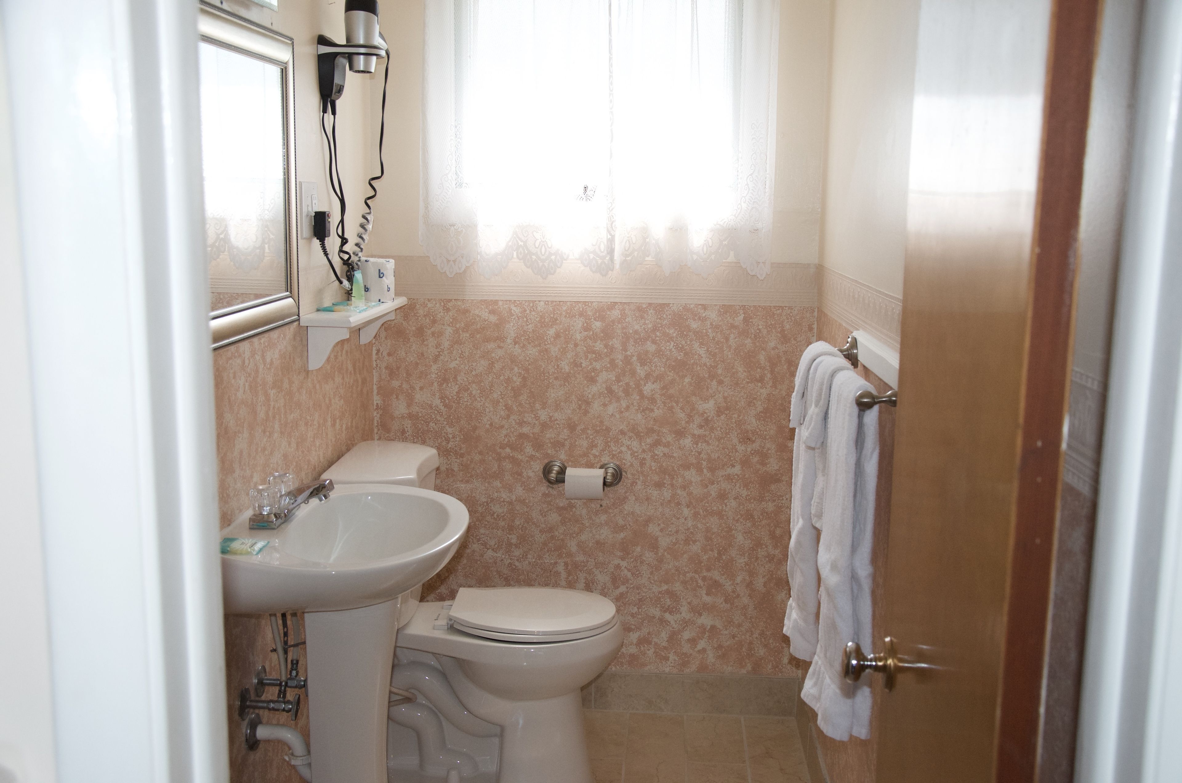 Ein Badezimmer mit Toilette, Waschbecken und Handtuchhalter.