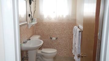 Ein Badezimmer mit Toilette, Waschbecken und Handtuchhalter.