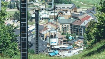 Sistema de teleférico con una cabina identificada como “Blue Mountain Village” en medio de un pueblo con diversos edificios y una ladera.