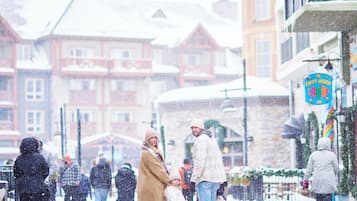 A snowy street scene with buildings and a sign.