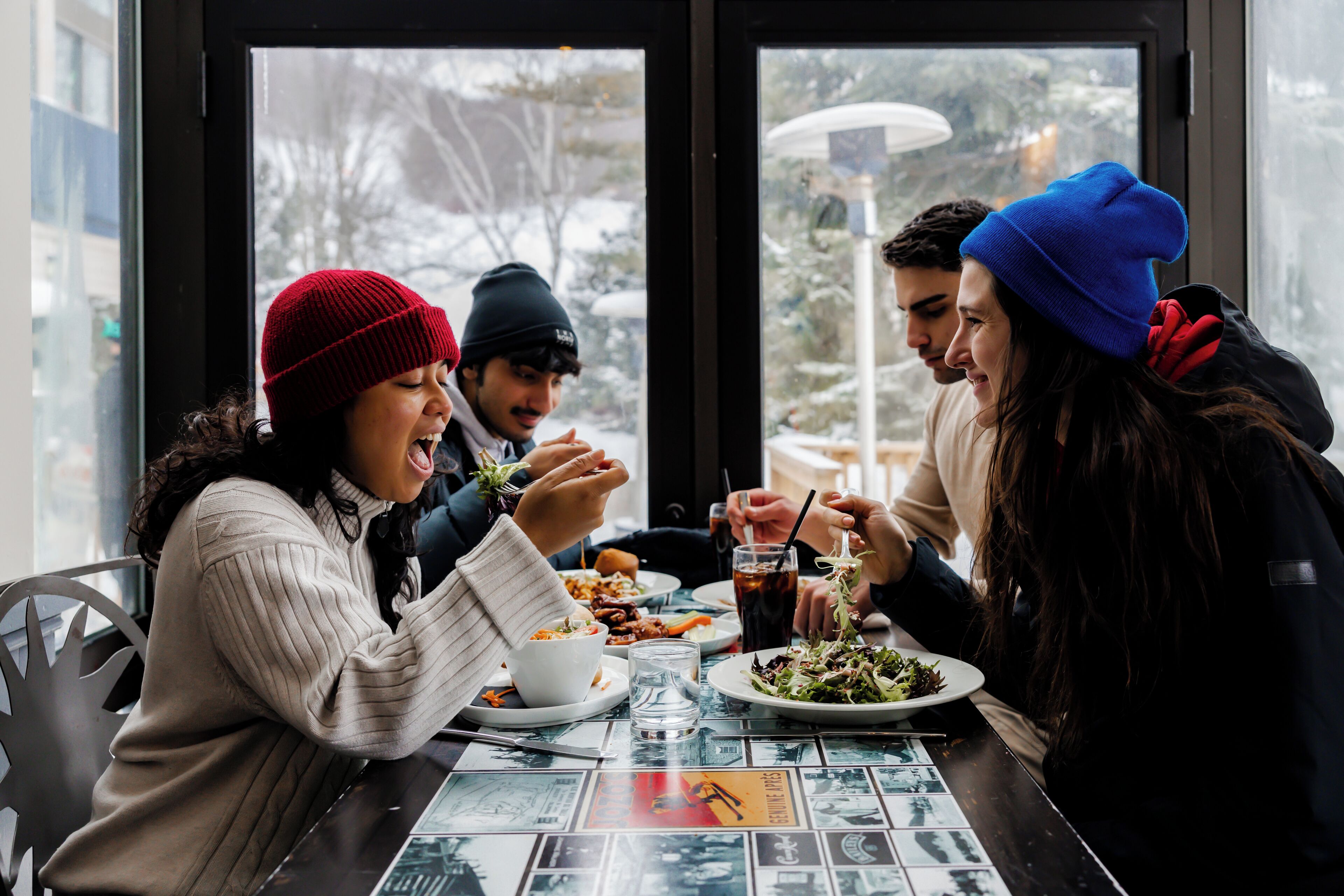 A group of people dining at a table with a view of the outdoors.