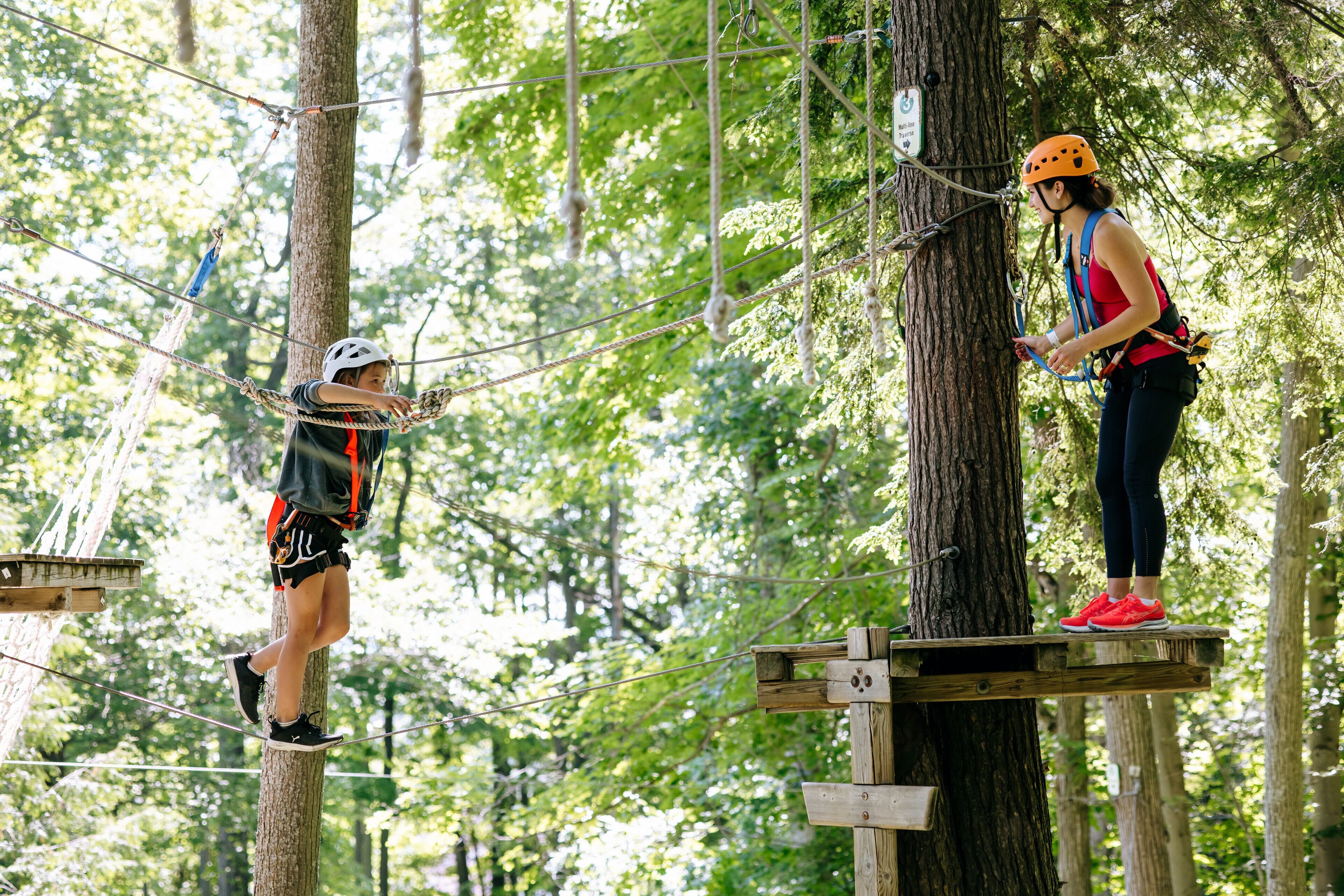Two people on a rope course in a forest.