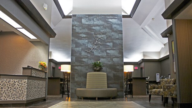 A lobby with a reception desk, a seating area, and a decorative wall. - Super 8 by Wyndham Copley Akron (Akron)